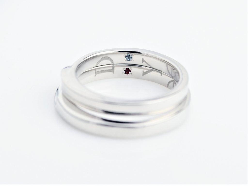 イニシャルの間には2人の誕生石入り イニシャルの間には2人の誕生石入り